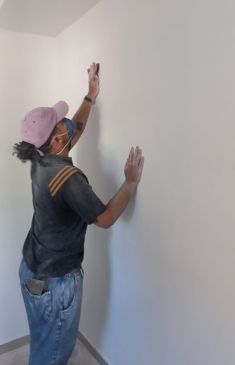 Profissional lixando a parede antes da pintura